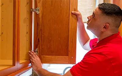 A My Handyman technician fixing a cabinet door.