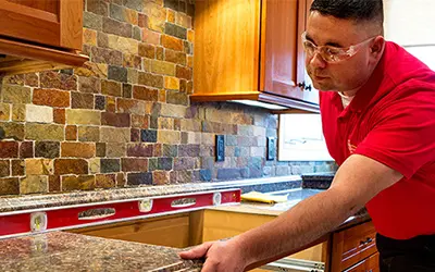 A My Handyman technician installing a cabinet.