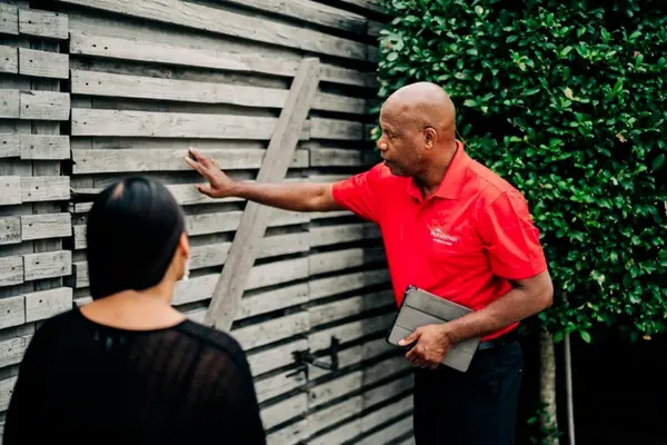 A My Handyman technician discussing power washing a fence with a client.