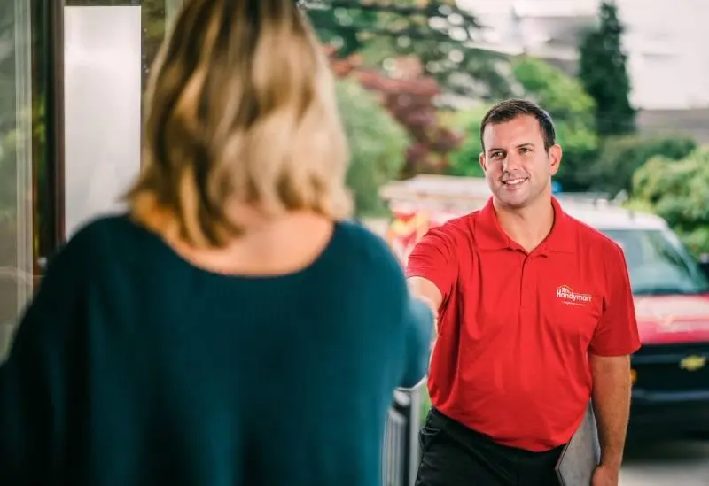 A woman greeting a My Handyman technician at the door.